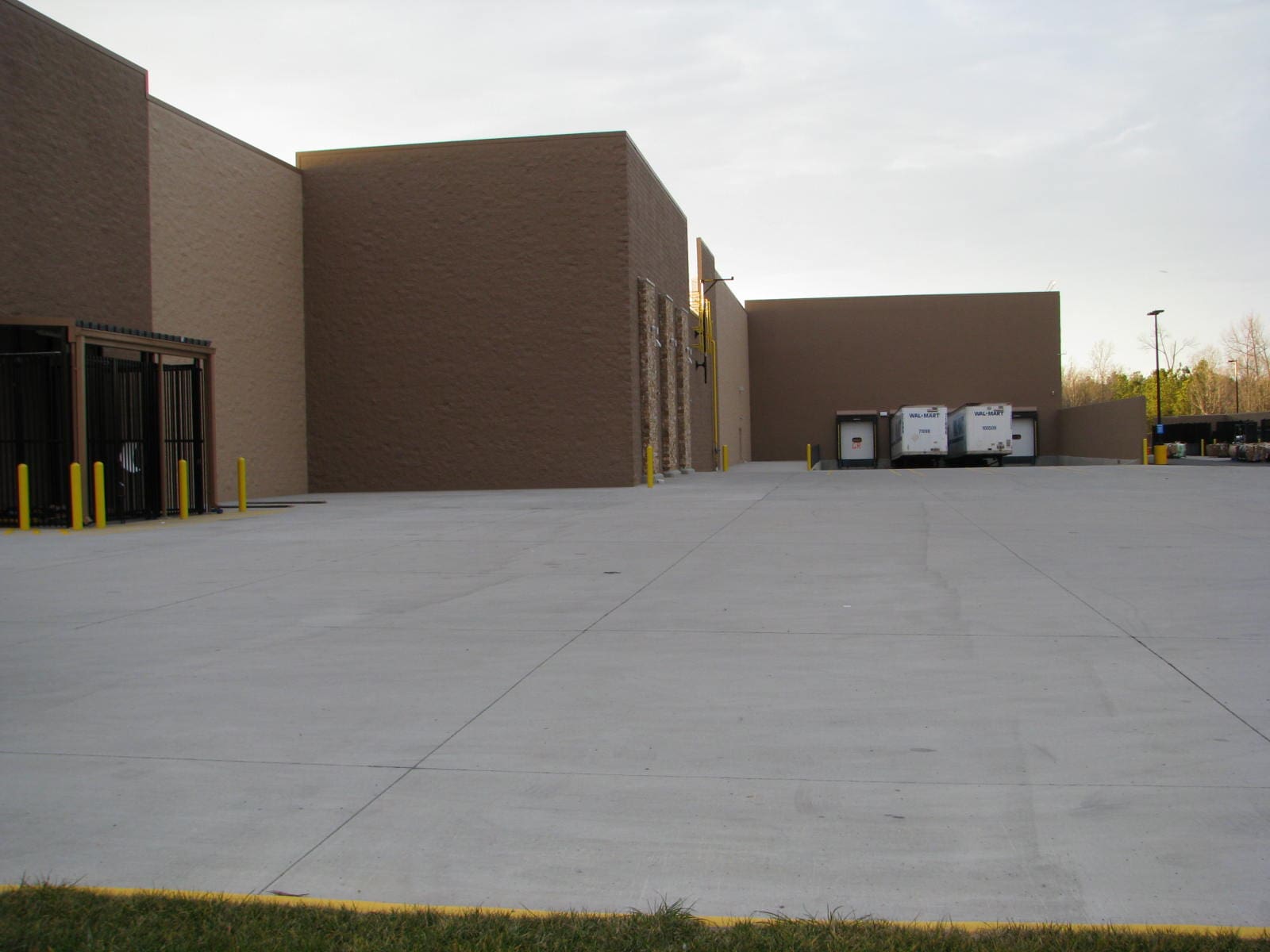 A large concrete building with two windows and three doors.