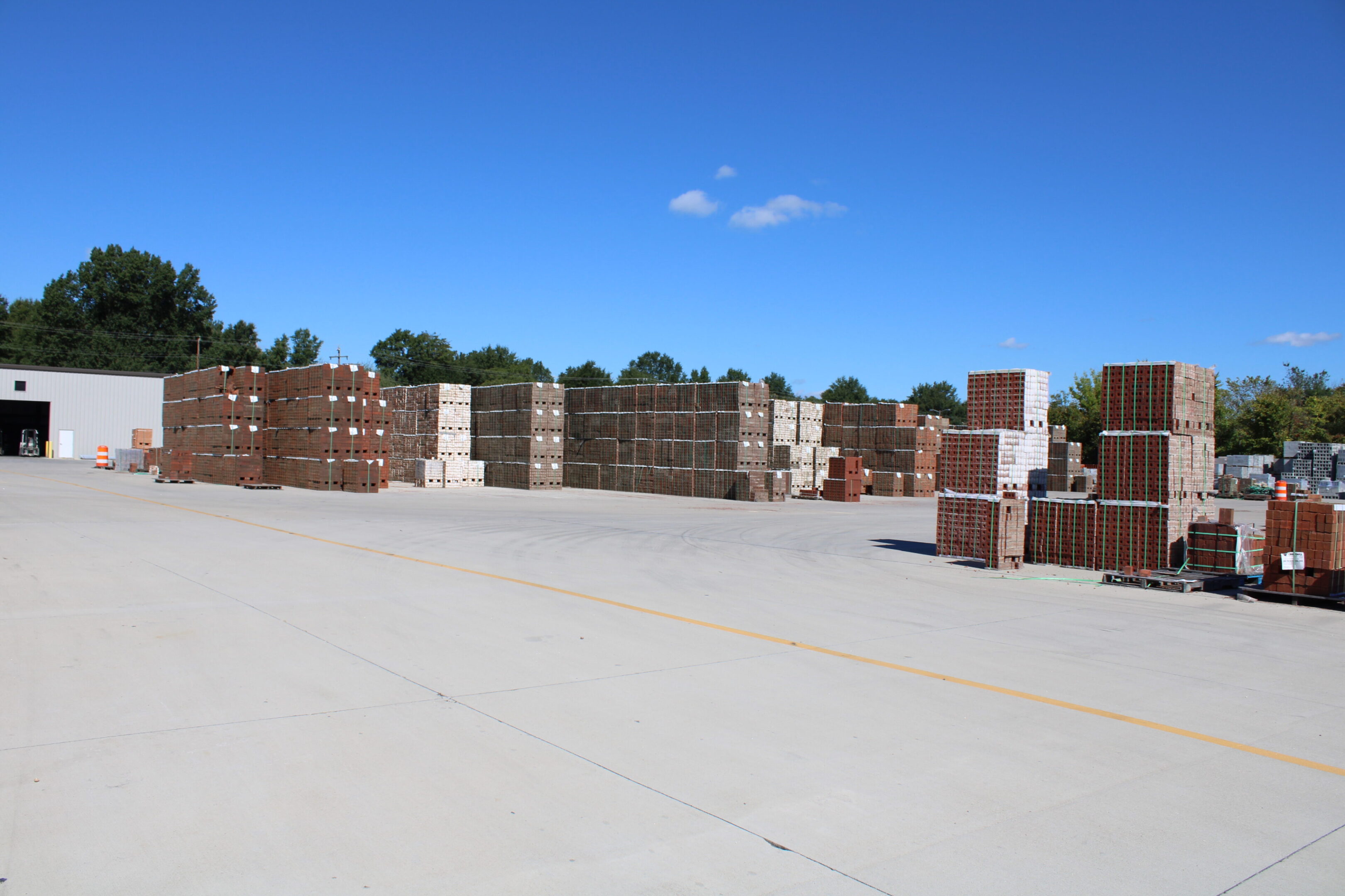 A lot of bricks stacked up in the middle of a yard.