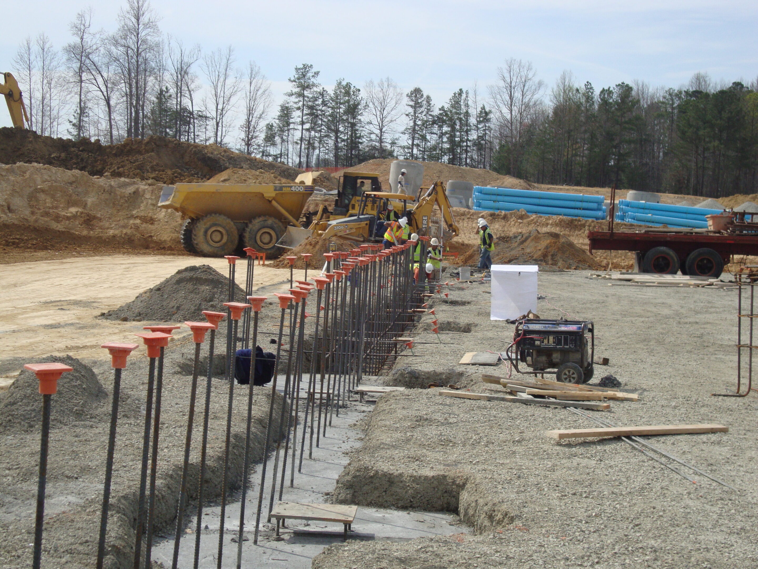 A construction site with workers and equipment on the ground.