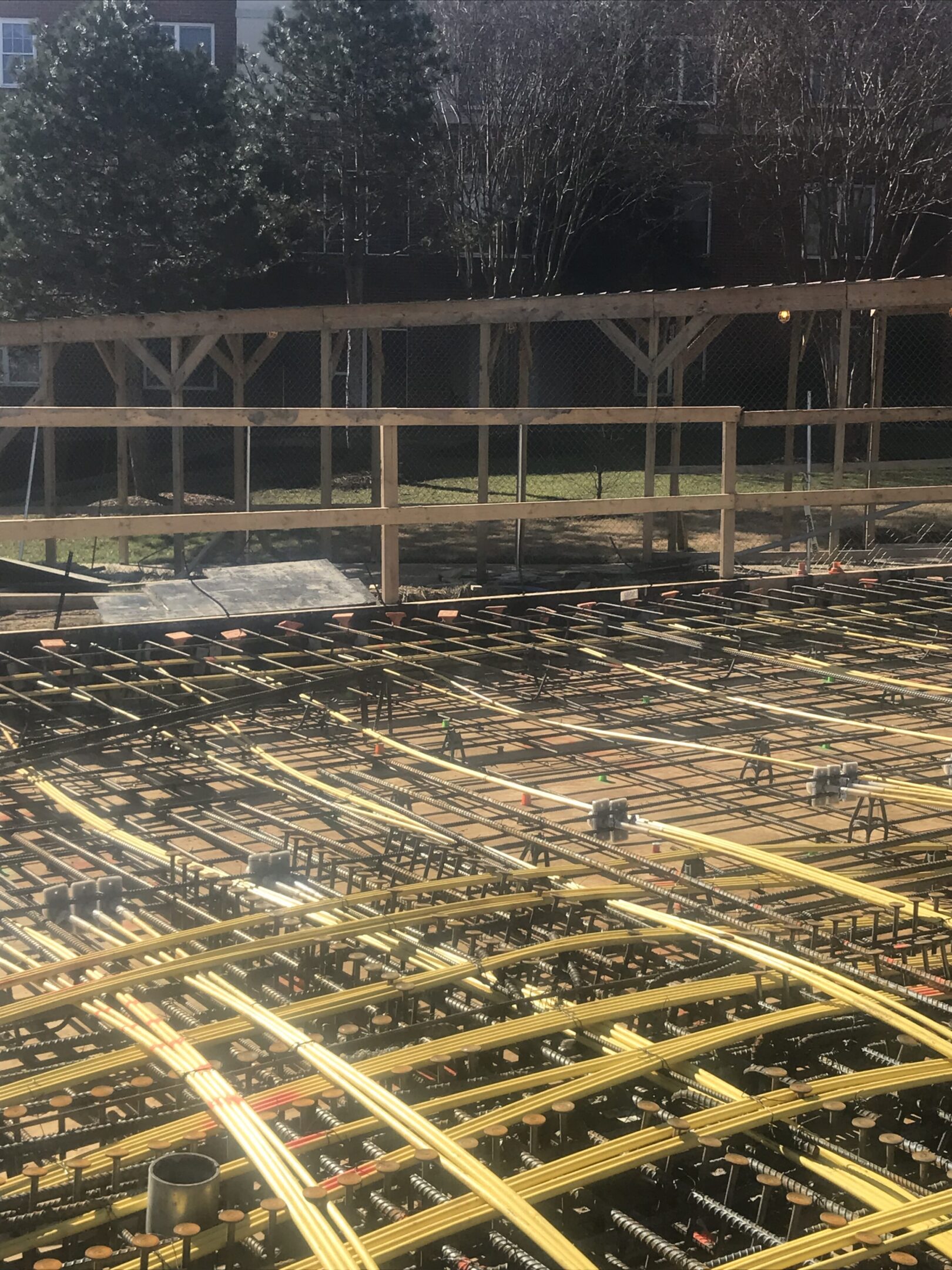 A large field of wooden planks with trees in the background.