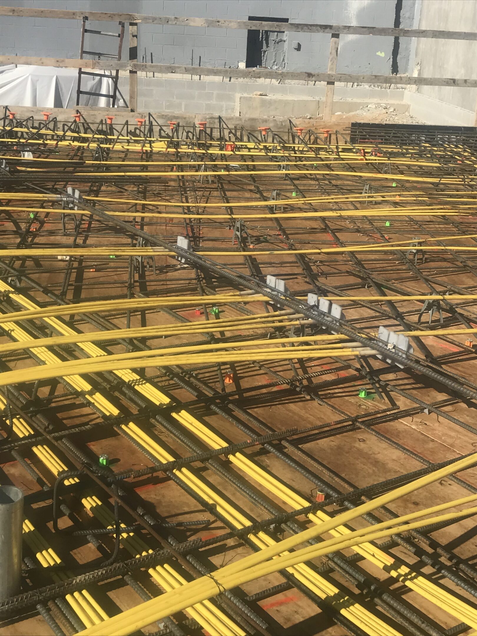 A floor with many yellow pipes and wires