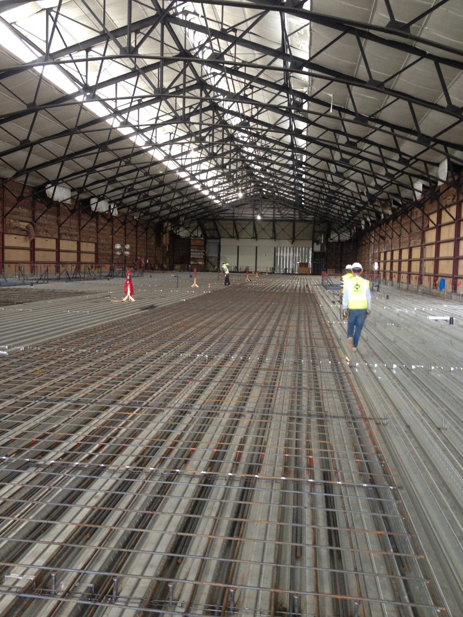 A man standing in an empty warehouse with many tracks.