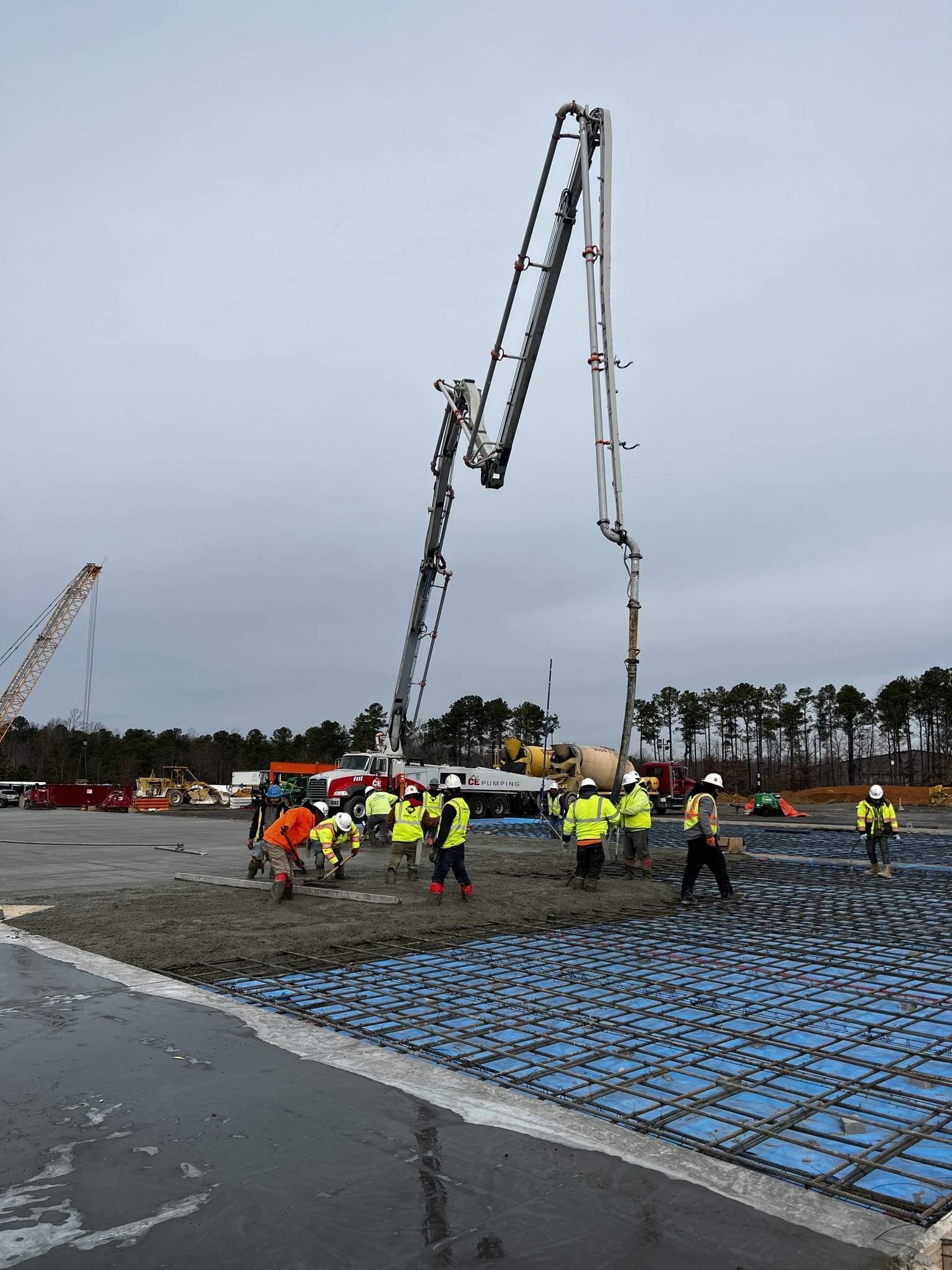 A group of people standing around on top of concrete.