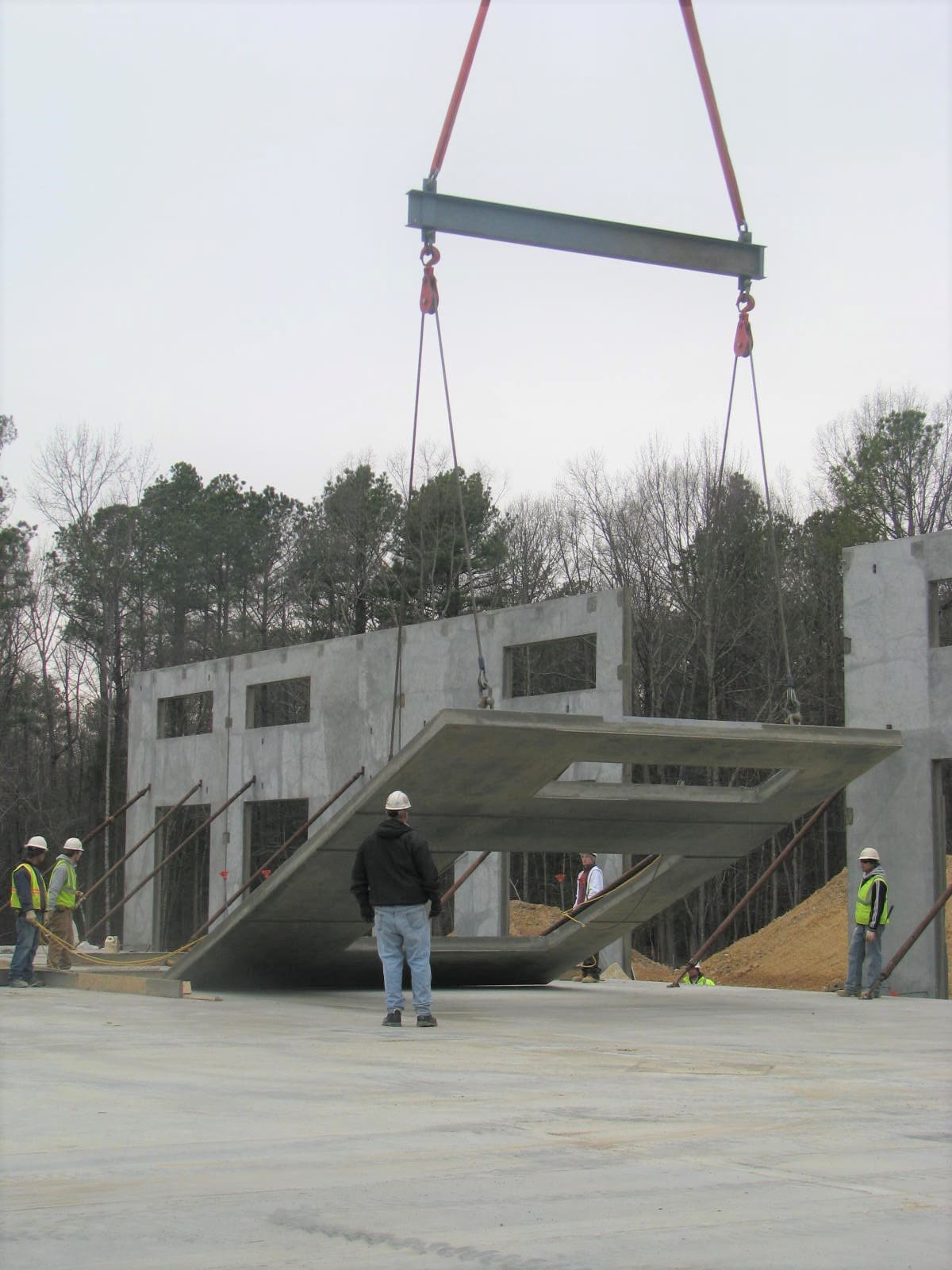 A man standing in front of a building being lifted by a crane.