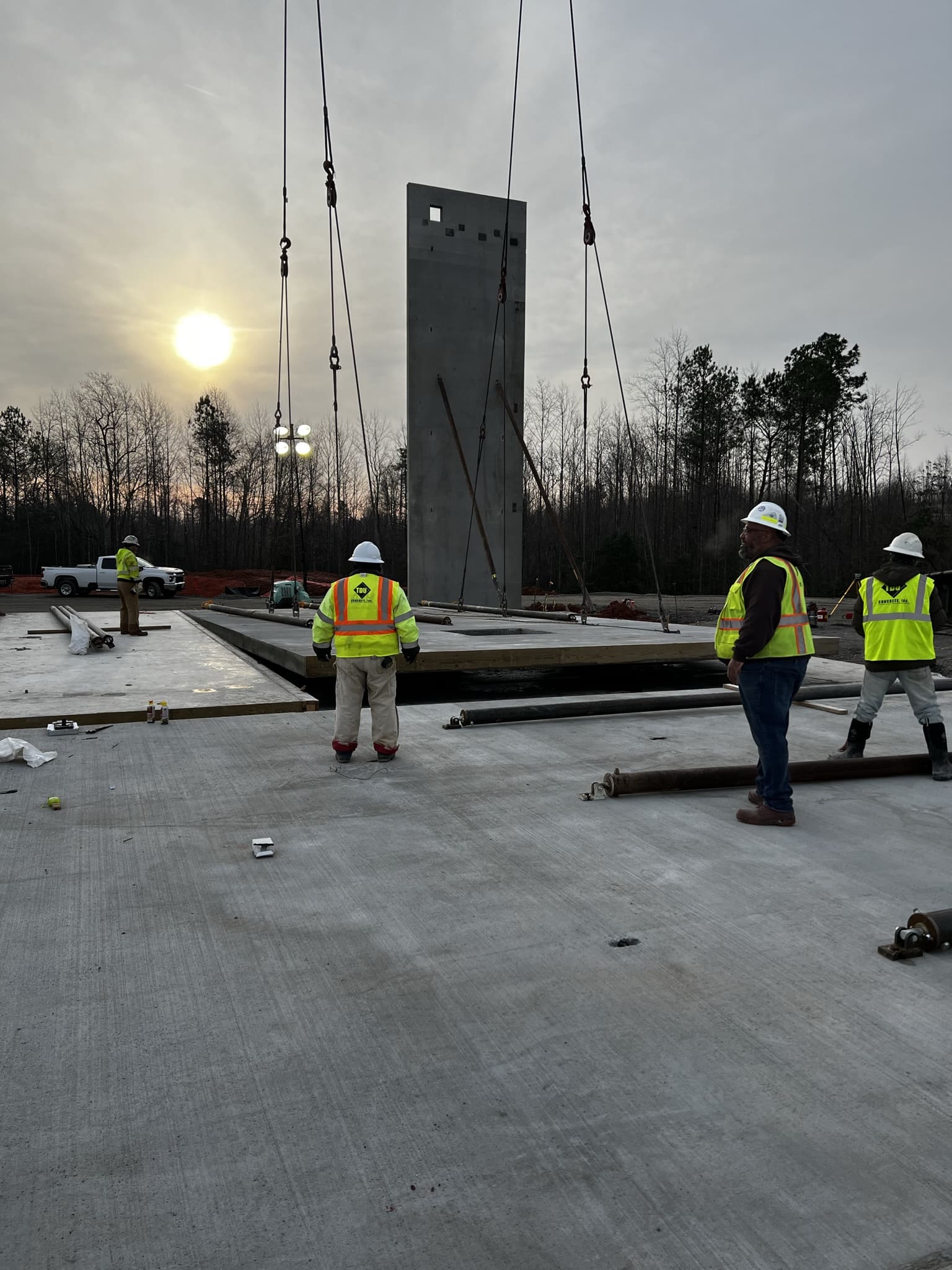 A group of people standing around in the middle of a construction site.