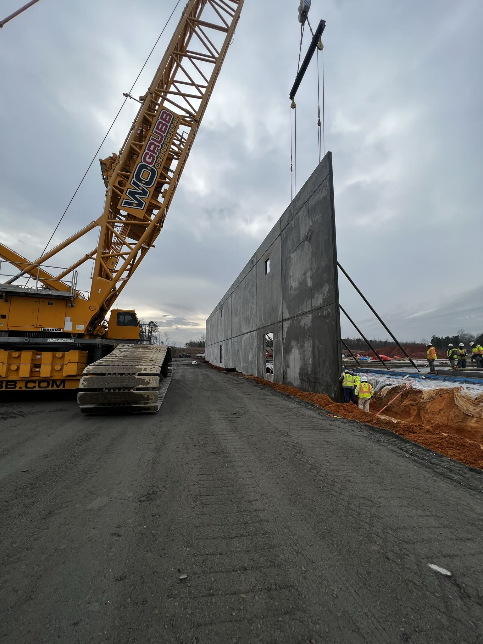 A crane is lifting a large piece of concrete.