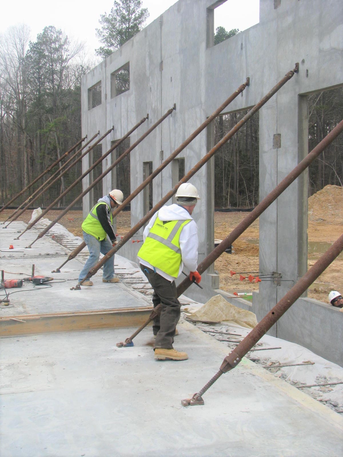 Two construction workers are working on a building.