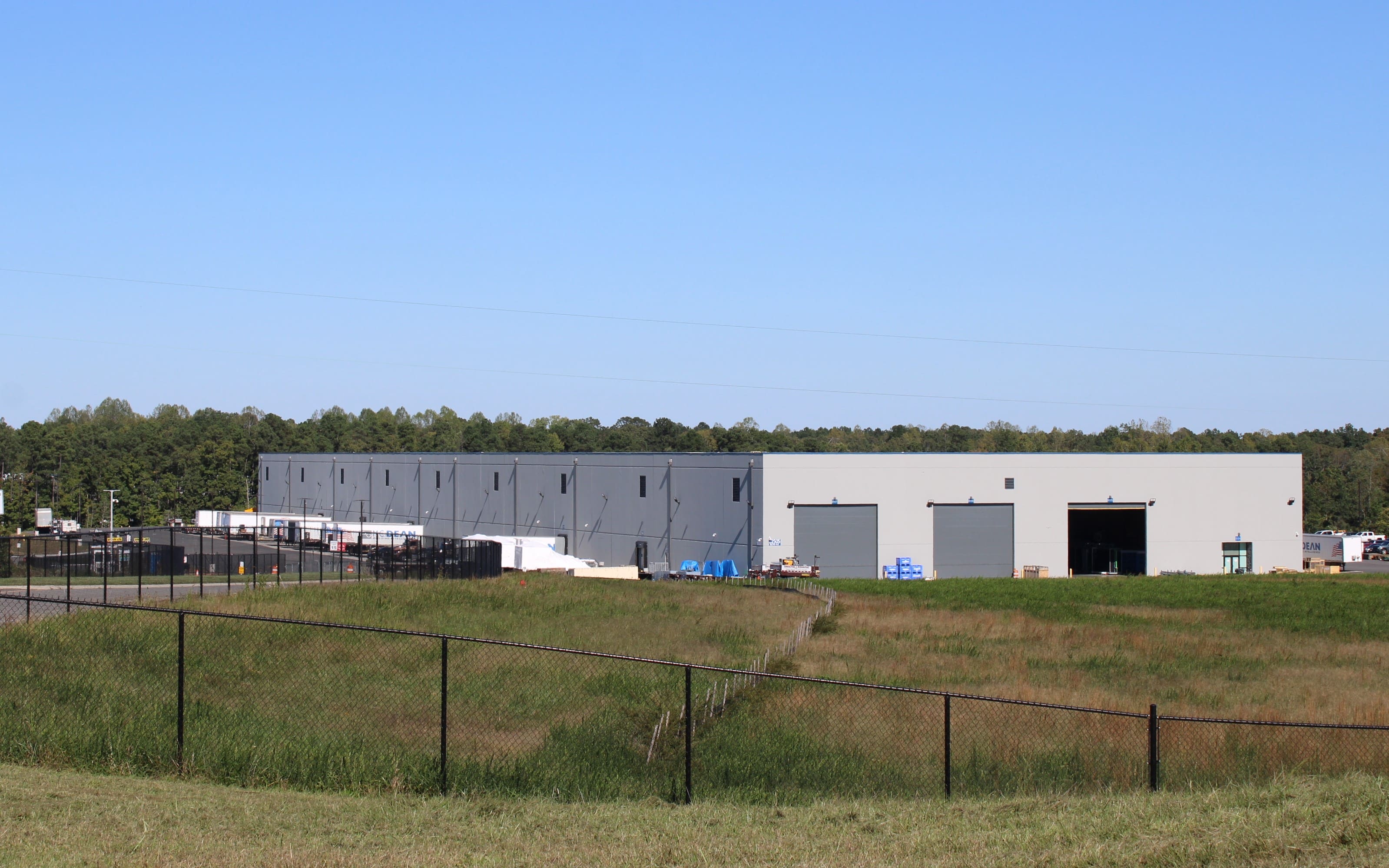 A large building with many windows in the middle of a field.