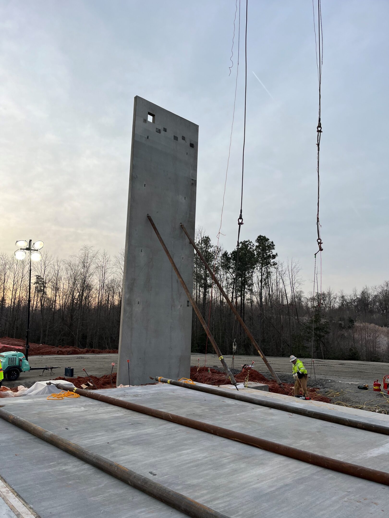 A large concrete slab being installed on top of a road.