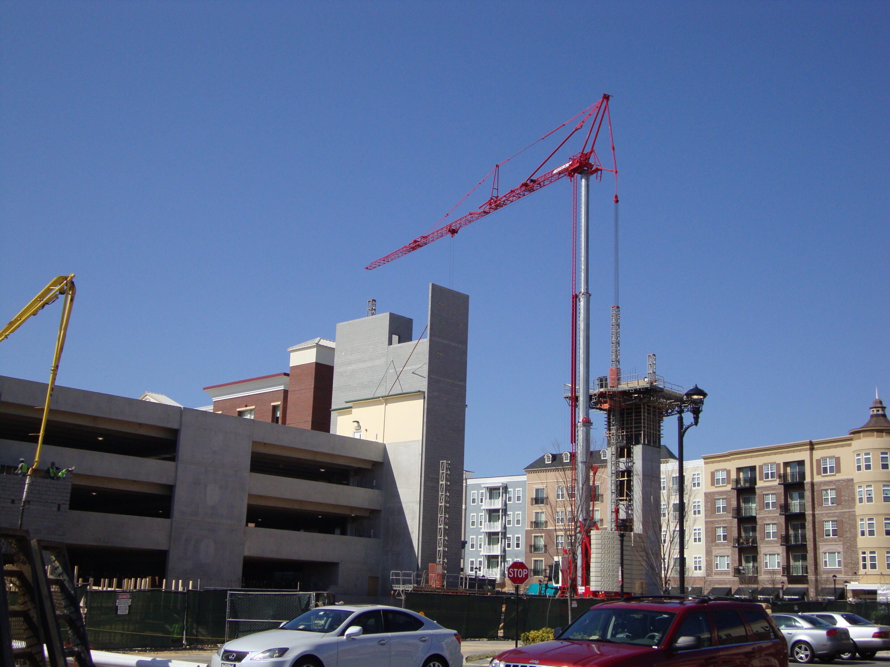 A crane is in the air over some cars.