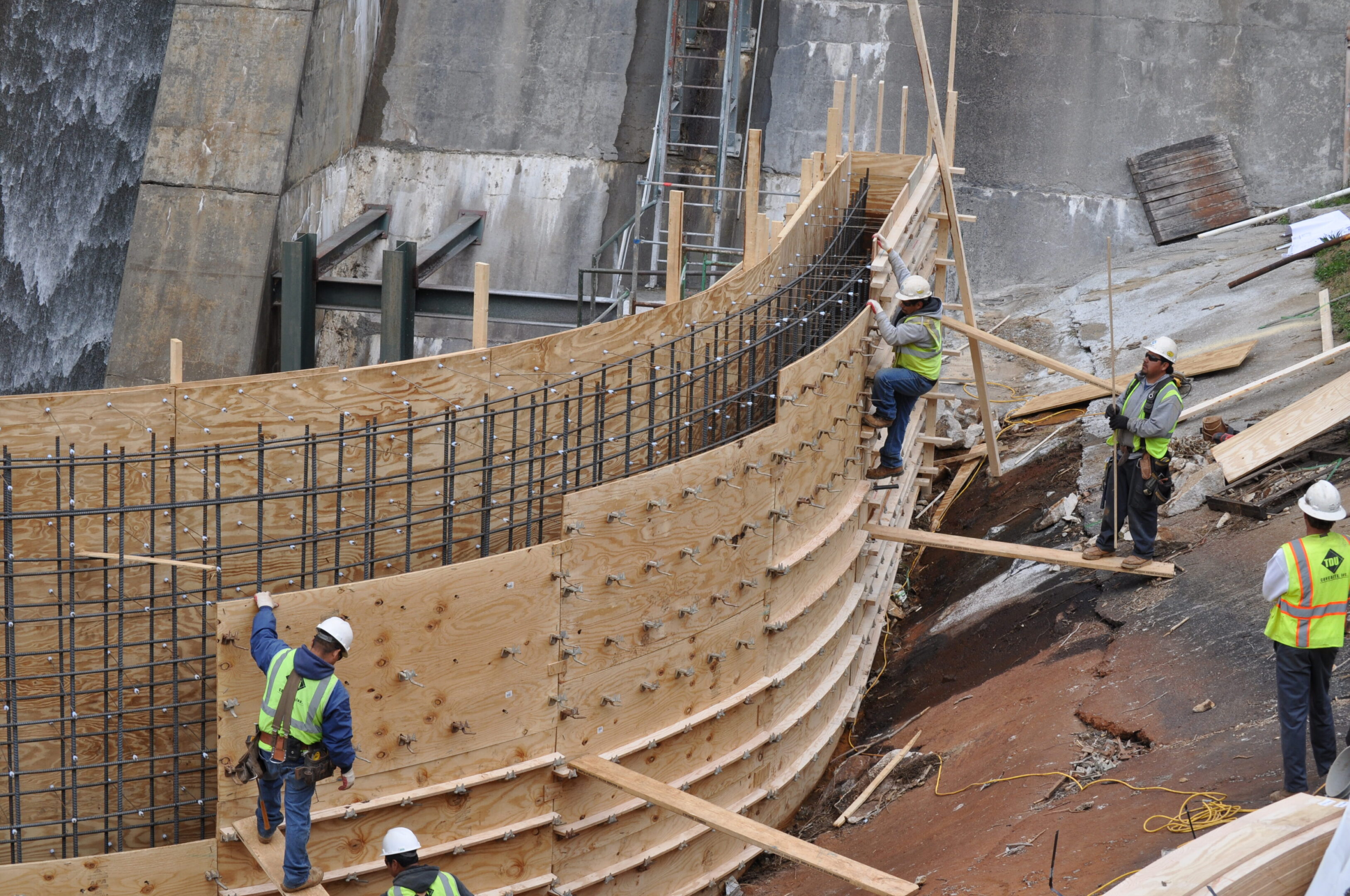 A group of construction workers standing on top of a wooden structure.