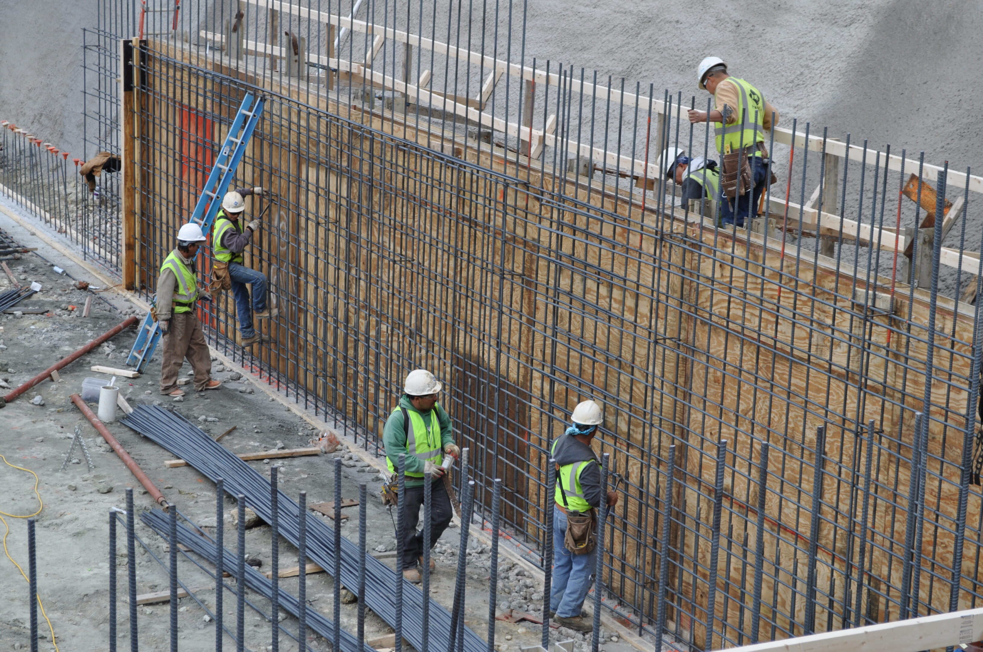 A group of construction workers working on the side of a building.