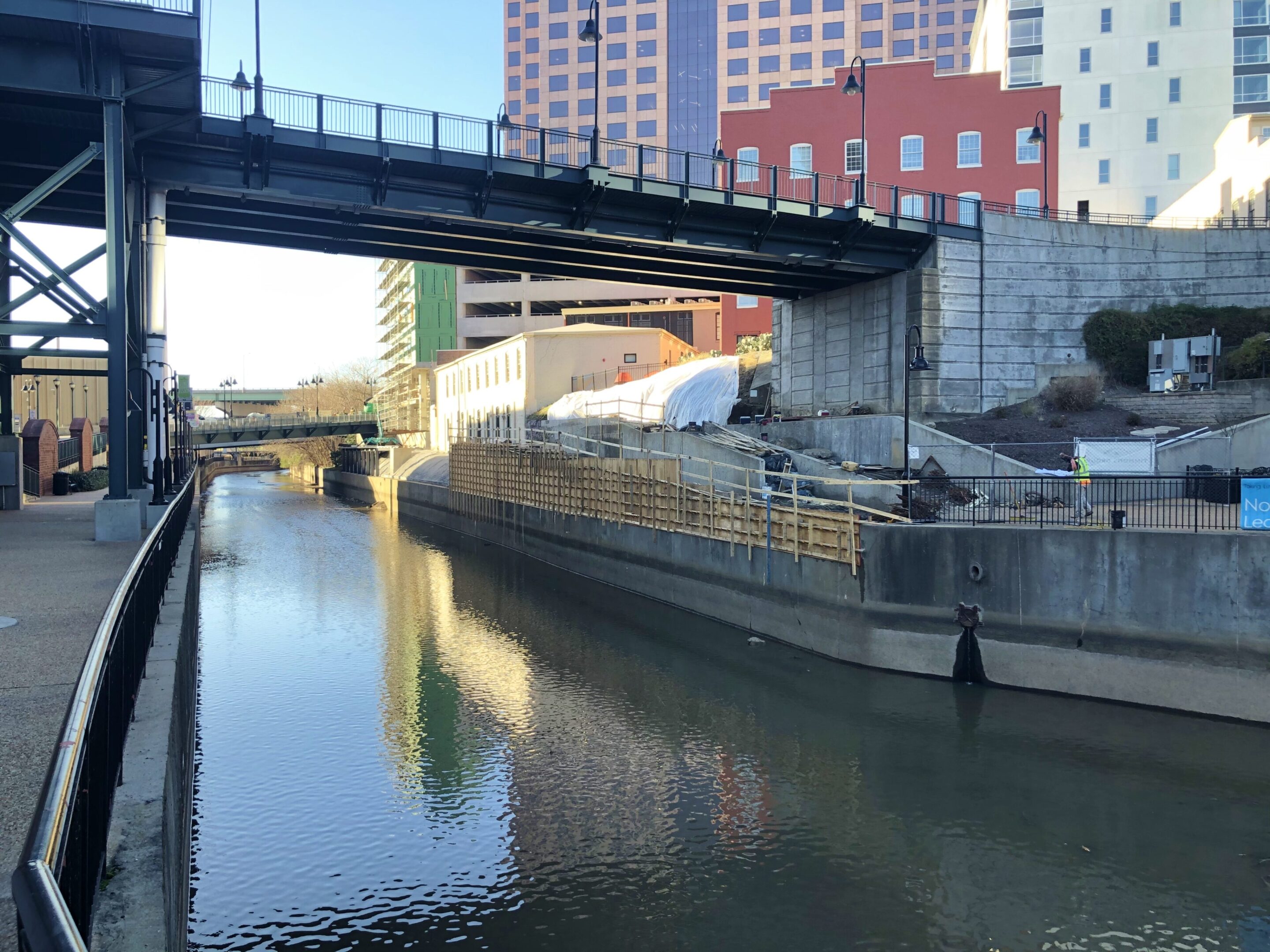 A bridge over the water near some buildings.