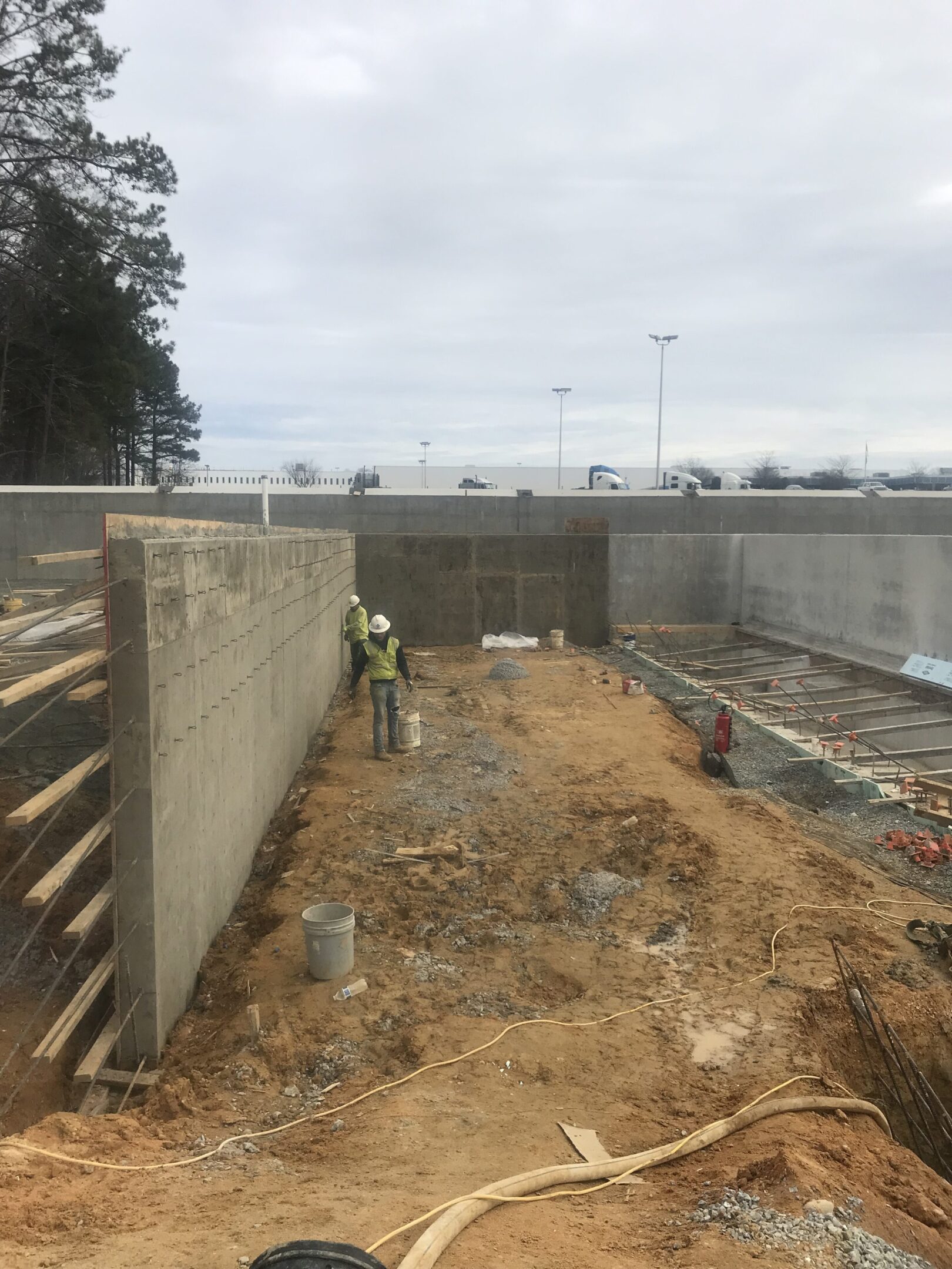 A construction worker standing next to a wall.